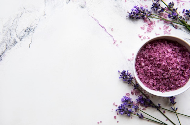 Cosmético SPA orgánico natural con lavanda. Sal de baño laicos plana y flores de lavanda sobre fondo de mármol. Cuidado de la piel, concepto de tratamiento de belleza.