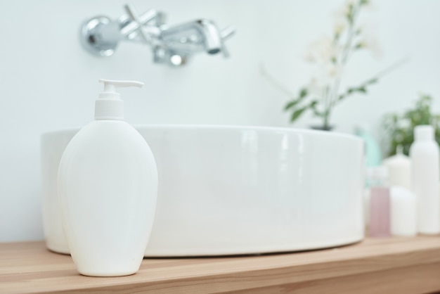 Cosméticos con accesorios cerca del lavabo en el baño.