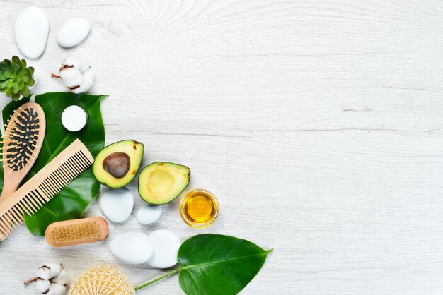 Cosméticos de aguacate aceite de aguacate sal marina y crema facial sobre un fondo de madera blanca El concepto de cosmética y spa Vista superior Espacio de copia libre