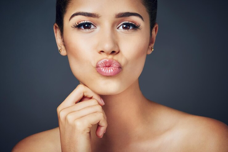 Foto cosméticos beijo e lábios de menina em estúdio com beleza brilho e boca brilhante com brilho saudável cuidados com a pele maquiagem e mulher com batom natural cor preenchimento de luxo e diversão em fundo cinza