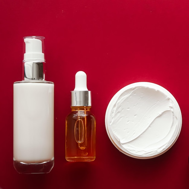 Cosméticos de belleza y productos para el cuidado de la piel sobre fondo rojo flatlay