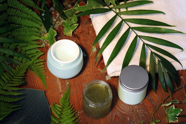 Foto cosméticos com folhas de palmeira na mesa de madeira
