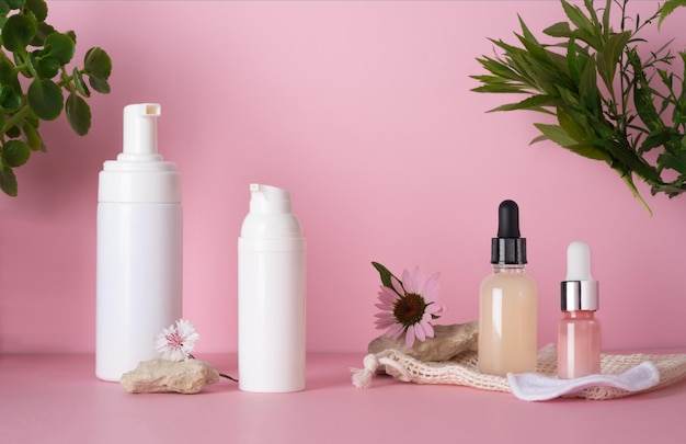 Foto cosméticos para el cuidado de la piel de la cara y el cuerpo con extractos de plantas con esponjas de algodón reutilizables para la cara