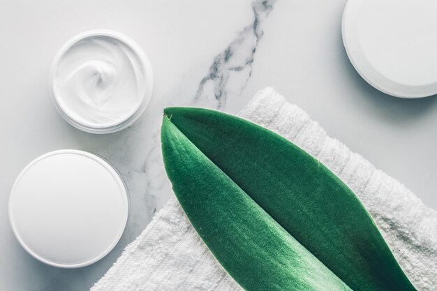 Cosméticos de beleza orgânicos em fundo flatlay de spa em casa de mármore