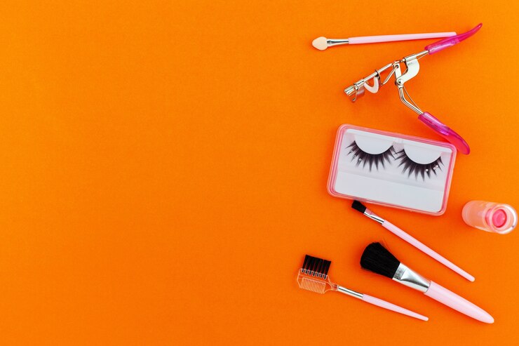 Foto cosméticos establecidos para mujeres sobre fondo de papel naranja