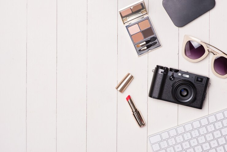 Foto cosméticos femeninos y artículos de moda en mesa con cámara y pasaporte. vista superior