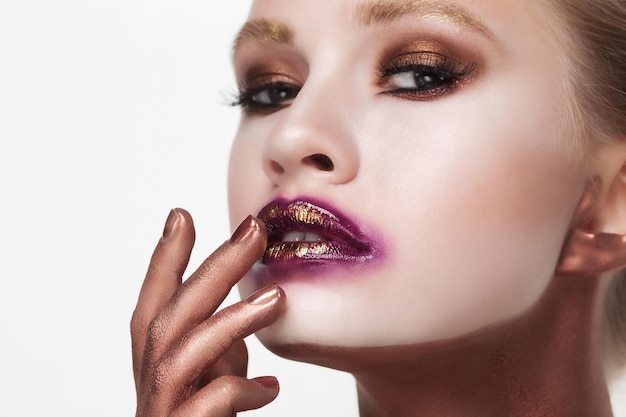 Cosméticos maquillaje y concepto de belleza mujer joven con maquillaje brillante de cerca