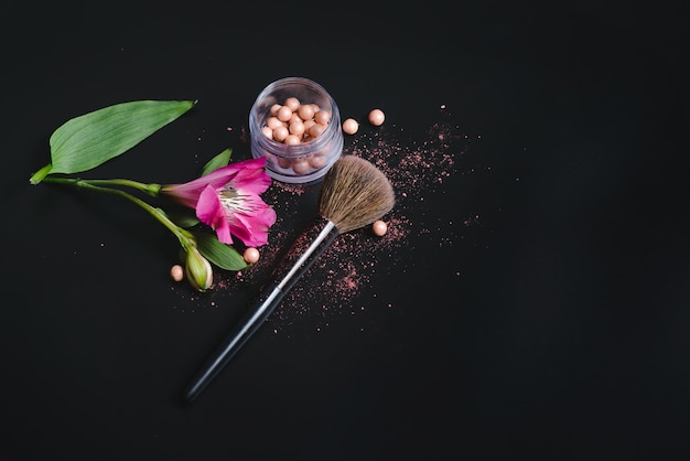 Cosméticos de maquillaje en una pared negra