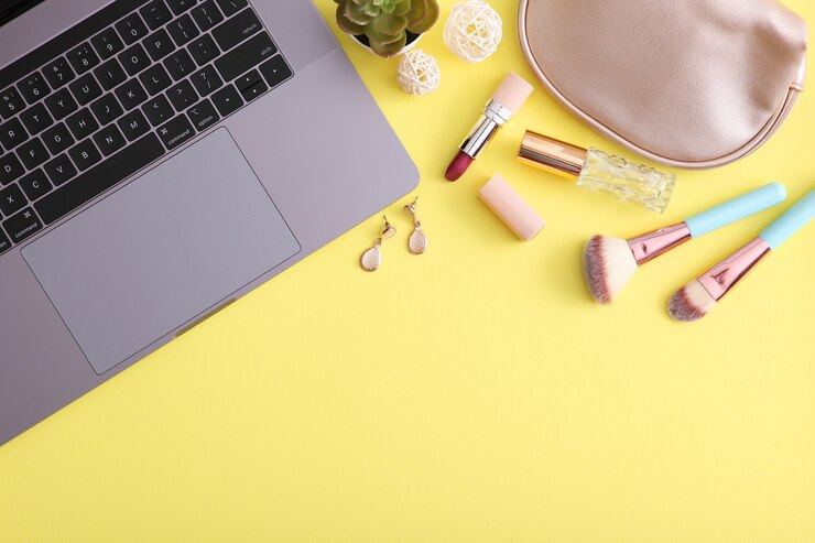 Foto cosméticos de maquillaje y portátil moderno en una vista superior de fondo coloreado