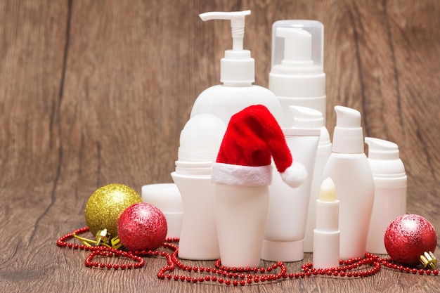 Foto cosméticos navideños para el cuidado de la piel varios productos cosméticos con gorro de papá noel espacio de copia