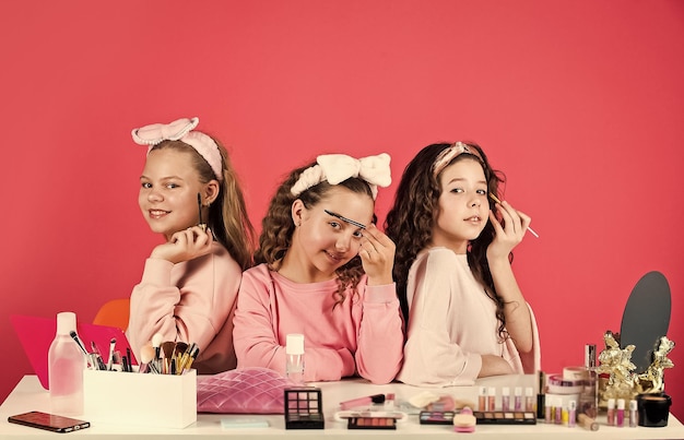 Cosméticos para niños Belleza y moda Hobby y diversión Niñas felices maquillándose Lindas hermanas juegan con cosméticos Salón de belleza Felicidad de hermandad Cuidado de la piel Rutina de belleza Maquillaje para niños