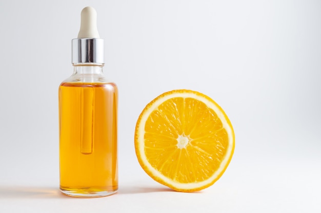 Foto cosméticos orgânicos spa com ingredientes à base de plantas: soro de vitamina c em frasco cosmético com conta-gotas.