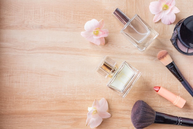 Cosméticos de perfume y maquillaje sobre fondo de madera