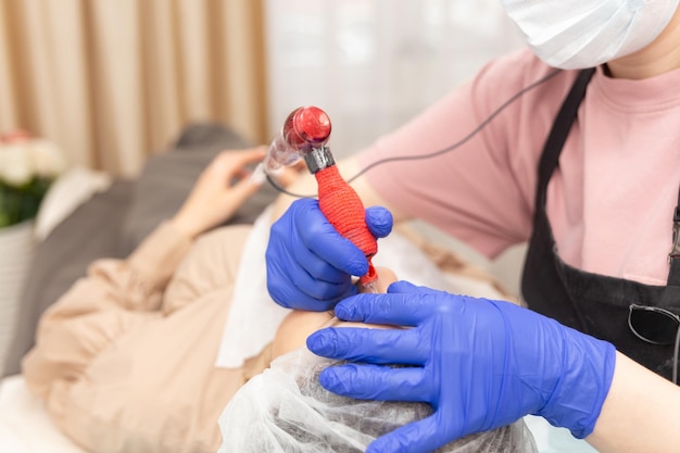 Cosmetóloga aplicando maquillaje permanente en las cejas- tatuaje de cejas.