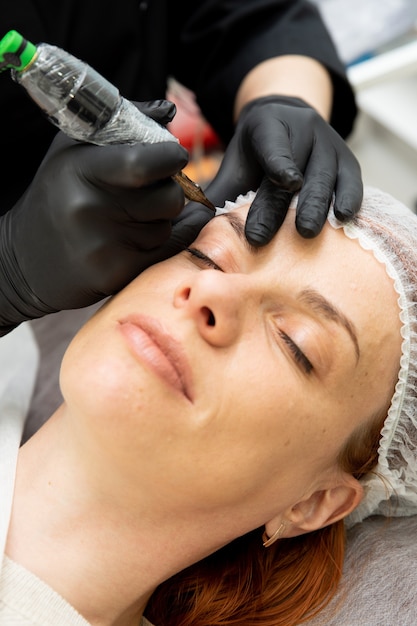 Cosmetóloga haciendo cejas maquillaje permanente