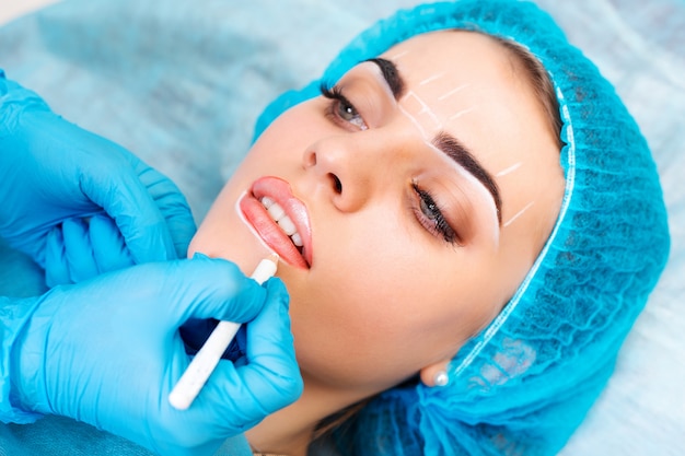 Cosmetóloga haciendo maquillaje permanente en rostro de mujer