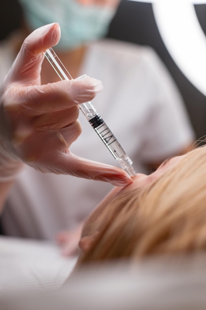 Cosmetóloga profesional mujer da inyecciones de vitaminas para hidratar la piel facial en la clínica de belleza Estética y belleza