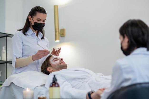 Cosmetóloga trabajando con el cliente en un salón de spa