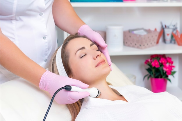 Cosmetologia de hardware. feche a foto de uma linda jovem com os olhos fechados, recebendo o procedimento de levantamento de rf no salão de beleza.