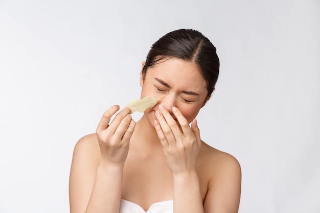 Cosmetología. Retrato de hermosa mujer modelo asiático con máscara en la nariz. Primer plano de mujer joven sana con piel suave pura y maquillaje natural fresco.