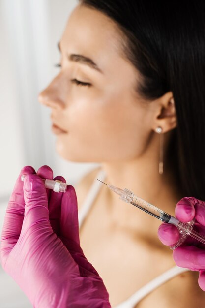 Cosmetologista antes de injetar ácido hialurônico nos lábios para aumento na clínica médica Injeções de aumento de lábios para garota atraente Tratamento facial rejuvenescedor cosmético