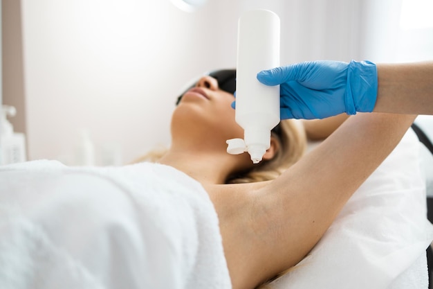 Cosmetologista aplica gel de depilação a laser na axila de clientes do sexo feminino