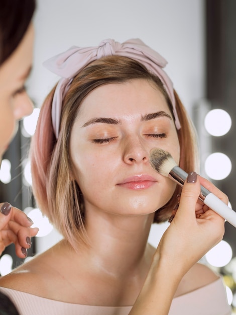 Cosmetologista aplicar base na mulher