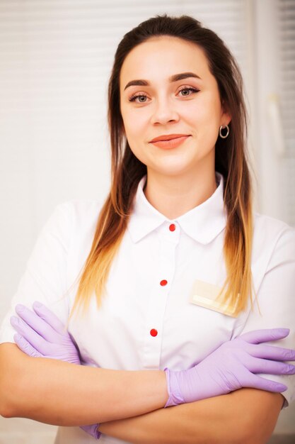 Cosmetologista de mulher de jaleco branco no estúdio de beleza