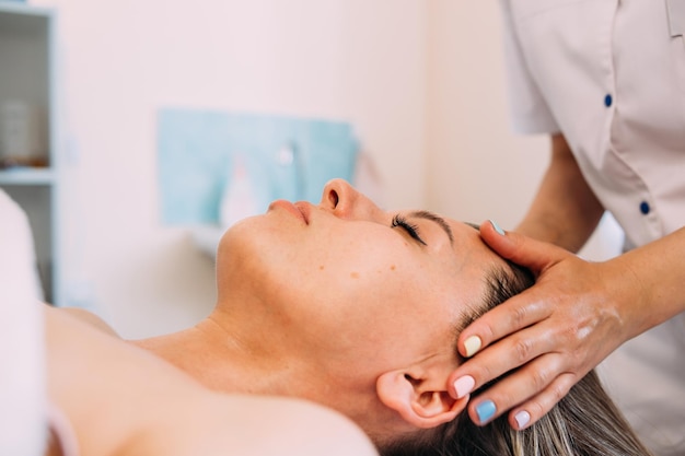 Cosmetologista faz massagem facial para beleza feminina cuidado da pele