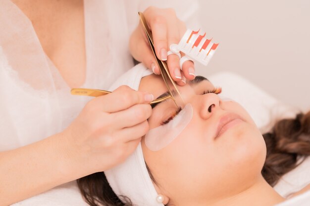 Cosmetologista habilidoso realizando procedimento de extensão de cílios