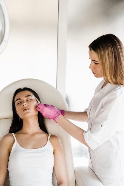 Cosmetologista injetando biorevitalização facial para efeito hidratante Biorevitalização facial para aumentar o tônus da pele reduzindo rugas e fortalecendo o oval do rosto