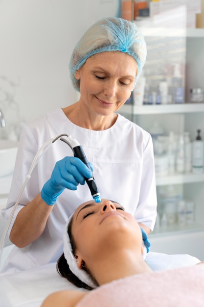 Cosmetologista profissional fazendo procedimento hidrafacial na clínica de cosmetologia