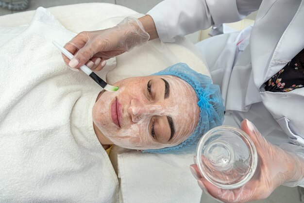 Cosmetologista realizando limpeza ultrassônica e rejuvenescimento do rosto da mulher em um centro de spa