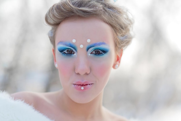 Cosplay de cuento de hadas de la reina de hielo Retrato de mujer en el vestido posando en el bosque nevado