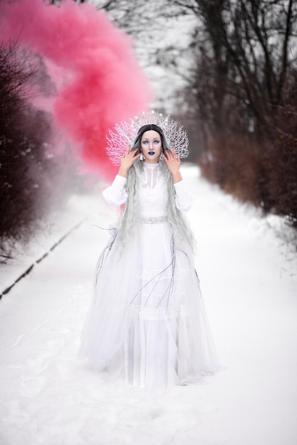 Cosplay reina de las nieves en el bosque en invierno