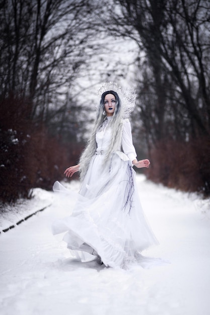 Cosplay reina de las nieves en el bosque en invierno