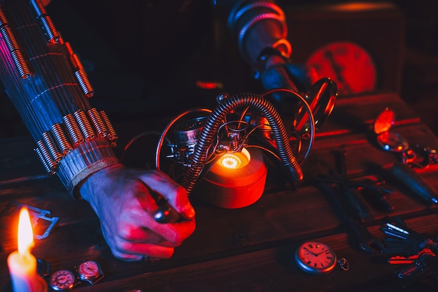 Cosplay Steampunk. Manos de un hombre, un ingeniero inventor que repara unas fantásticas gafas post-apocalípticas