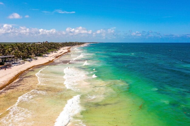 Foto costa aérea de tulum junto a la playa con un mágico mar del caribe y pequeñas chozas junto a la costa beauti