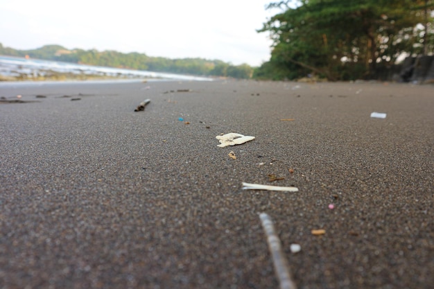 Costa arenosa do mar sujo, poluição ambiental, poluição plástica no oceano