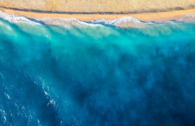 Costa com ondas como pano de fundo da vista superior Fundo de água azul do drone Paisagem marítima de verão do ar Paisagem natural para design