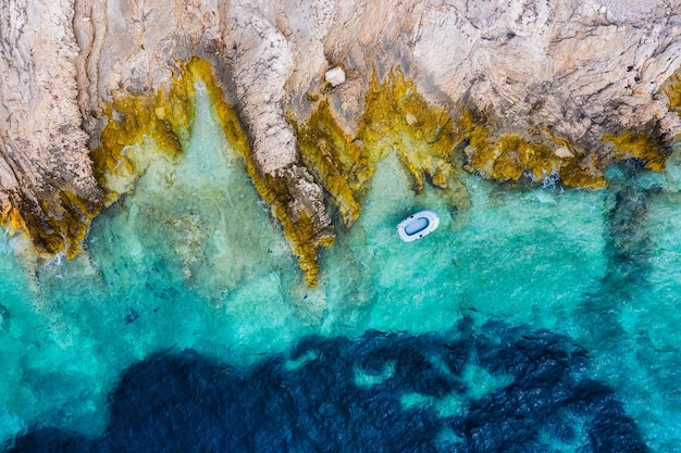 Costa de Croacia con rocas y barco como fondo desde la vista superior Fondo de agua azul desde la vista superior Paisaje marino de verano desde el aire Imagen de viaje