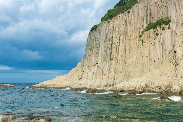 Costa da ilha de Kunashir com penhasco de basalto colunar Cabo Stolbchaty