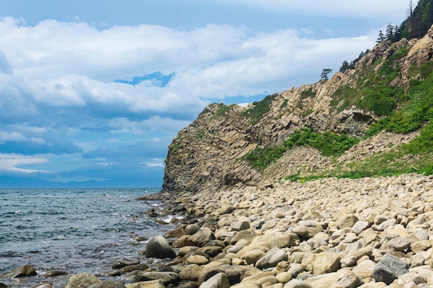 Costa da ilha de Kunashir com penhasco de basalto