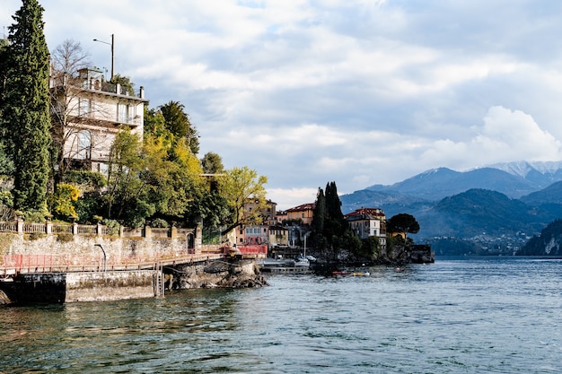 Costa de Varenna com píer e casas antigas, lago como itália