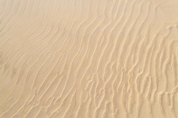 Costa do mar com close-up de areia ondulada. Fundo de textura de areia. Conceito de verão e férias. Vista do topo