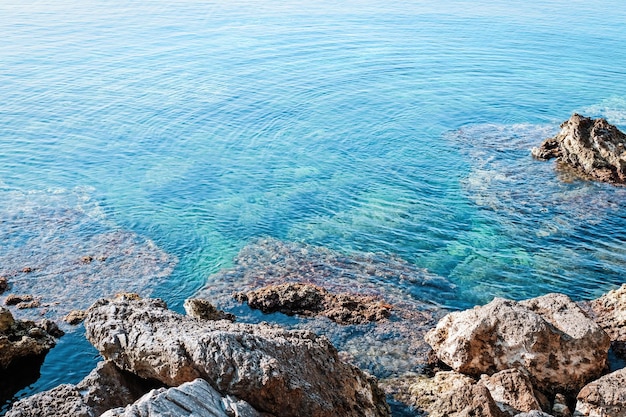 Costa do mar com pedras em dia ensolarado