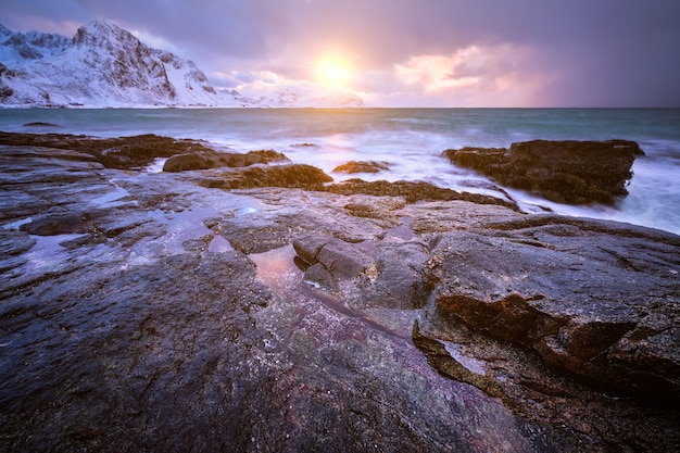 Costa do mar norueguês na costa rochosa no fiorde no pôr do sol