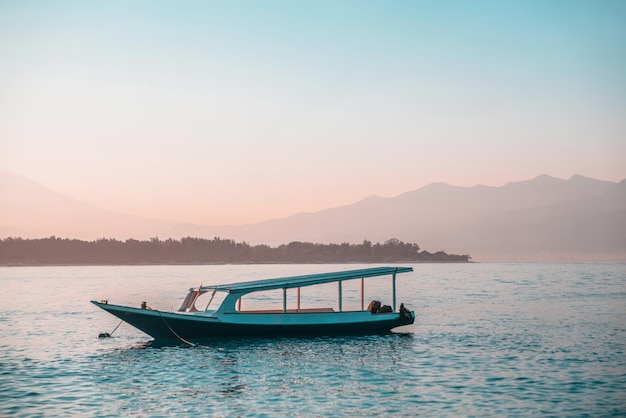 Costa de Gili Trawangan Hermosa vista del barco tradicional sobre fondo azul del océano y el cielo Puesta de sol