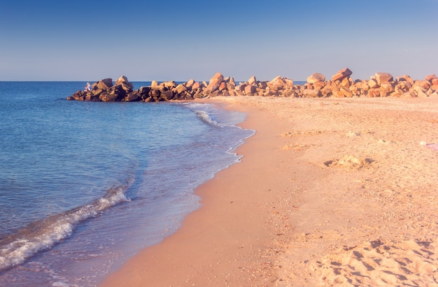 La costa del mar con adoquines en el horizonte.