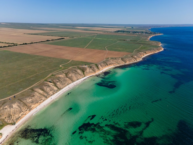 Costa del mar con agua clara rodada en un avión no tripulado en Crimea en el verano